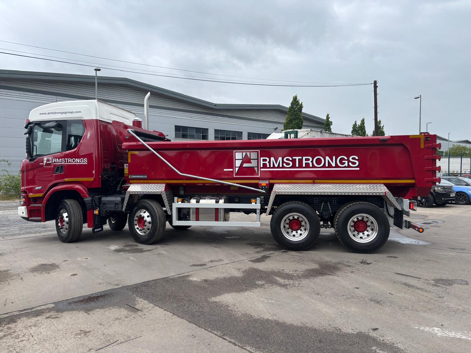 Red commercial tipper showing completed body paintwork