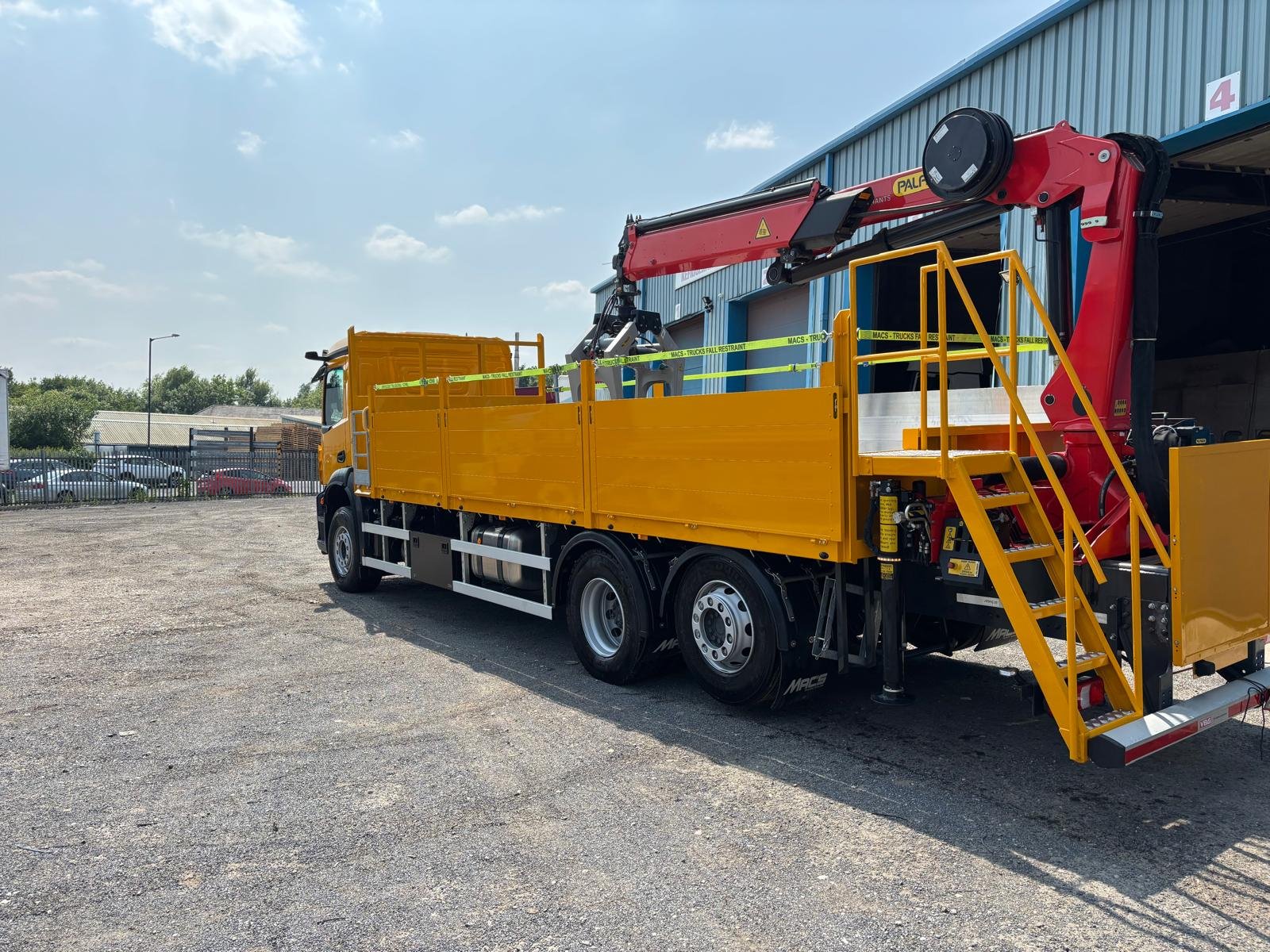 Yellow dropside and crane commercial vehicle after painting