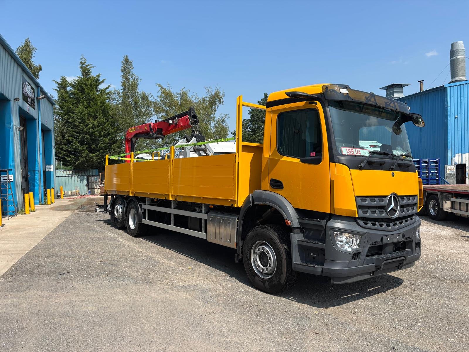 Yellow commercial crane vehicle with completed body and cab paintwork