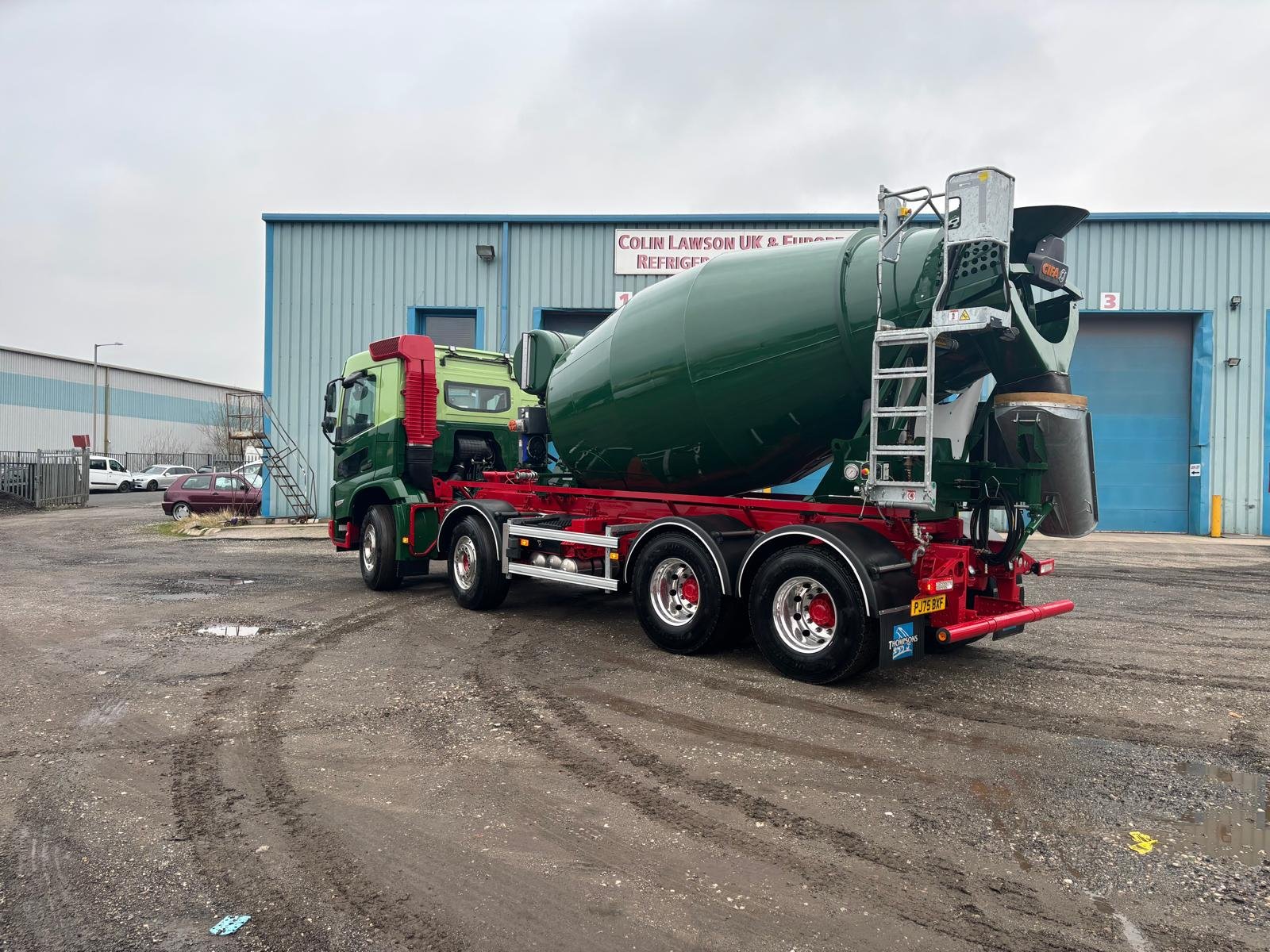 Green concrete mixer showing the completed cab and drum finish