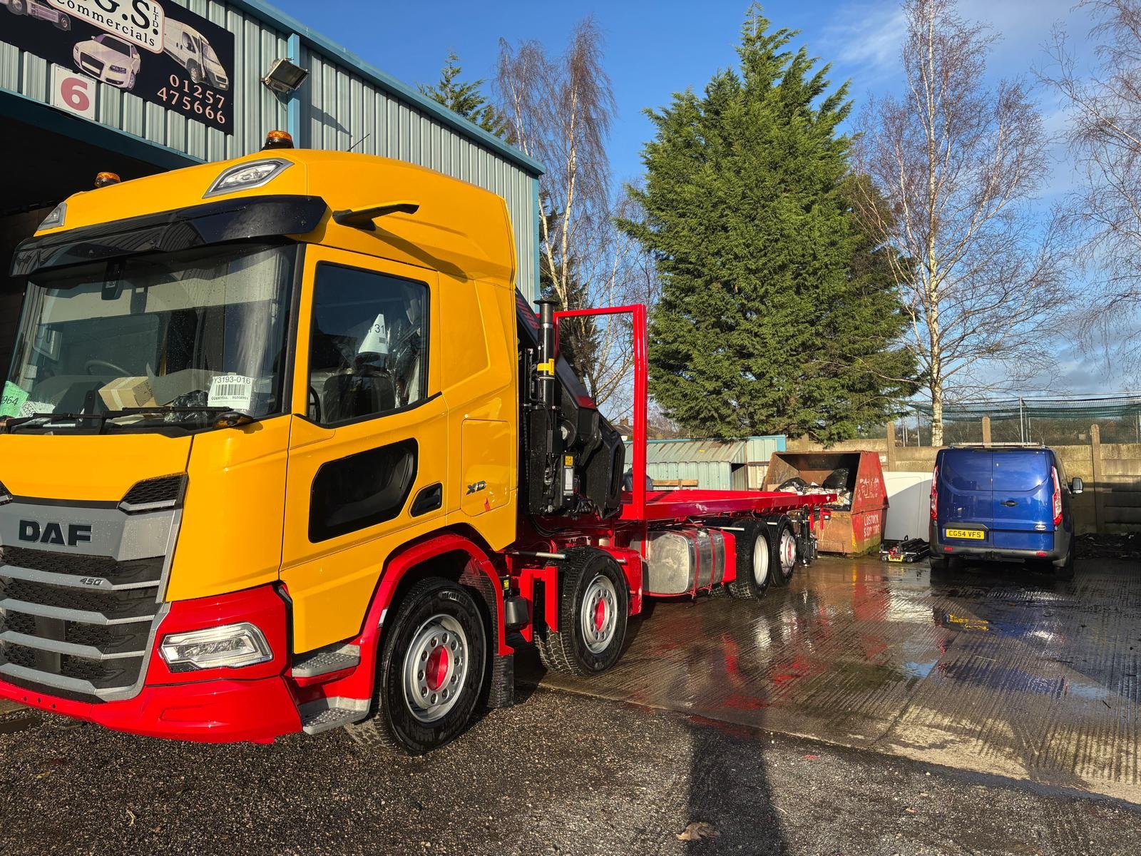 Yellow DAF crane and flatbed vehicle after painting